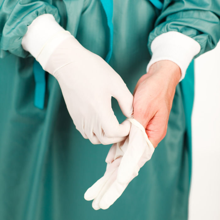 Young surgeon before an operation with gloves