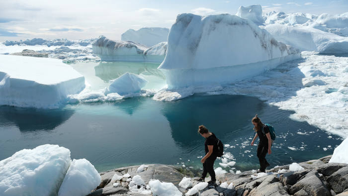 ILULISSAT, GREENLAND - JULY 30: Visitors walk among free-floating ice jammed into the Ilulissat Icefjord during unseasonably warm weather on July 30, 2019 near Ilulissat, Greenland. The Sahara heat wave that recently sent temperatures to record levels in parts of Europe is arriving in Greenland. Climate change is having a profound effect in Greenland, where over the last several decades summers have become longer and the rate that glaciers and the Greenland ice cap are retreating has accelerated. (Photo by Sean Gallup/Getty Images)