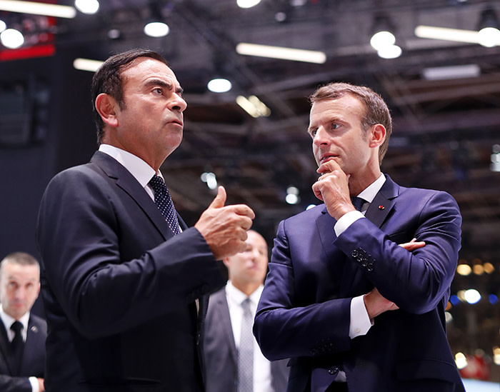 French President Emmanuel Macron (R) listens to CEO of French car maker Renault Carlos Ghosn during an official visit at the Paris auto show in Paris, on October 3, 2018. (Photo by Ian LANGSDON / POOL / AFP) (Photo credit should read IAN LANGSDON/AFP via Getty Images)