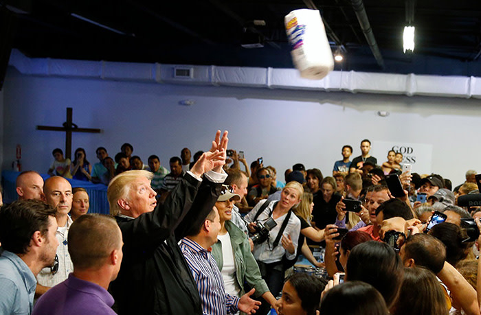 U.S. President Donald Trump throws rolls of paper towels into a crowd of local residents affected by Hurricane Maria as he visits Calgary Chapel in San Juan, Puerto Rico, U.S., October 3, 2017. REUTERS/Jonathan Ernst - HP1EDA31DJO0C