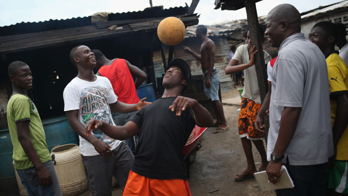MONROVIA, LIBERIA - AUGUST 15: Young men show off their ball handling skills in the West Point slum on August 15, 2014 in Monrovia, Liberia. Poor sanitation and close quarters have contributed to the spead of the Ebola virus, which is transmitted through bodily fluids. The epidemic has killed more than 1,000 people in four West African countries. (Photo by John Moore/Getty Images)