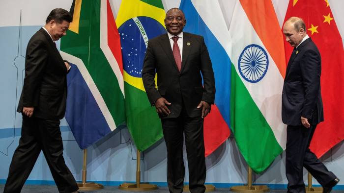 TOPSHOT - (LtoR) China's President Xi Jinping, South Africa's President Cyril Ramaphosa and Russia's President Vladimir Putin arrive to pose for a group picture during the 10th BRICS (acronym for the grouping of the world's leading emerging economies, namely Brazil, Russia, India, China and South Africa) summit on July 26, 2018 at the Sandton Convention Centre in Johannesburg, South Africa. (Photo by Gianluigi GUERCIA / POOL / AFP) (Photo credit should read GIANLUIGI GUERCIA/AFP/Getty Images)