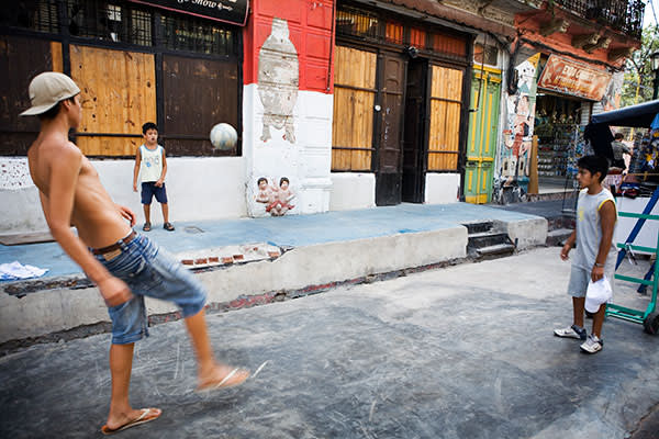 Boys play football in Caminito, a cultural centre popular with tourists