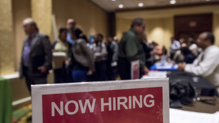 &quot;Now Hiring&quot; signage is displayed as job seekers wait in line to enter the San Jose Career Fair in San Jose, California, U.S., on Tuesday, Nov. 10, 2015. The U.S. Department of Labor is scheduled to release initial jobless claims figures on November 12. Photographer: David Paul Morris/Bloomberg