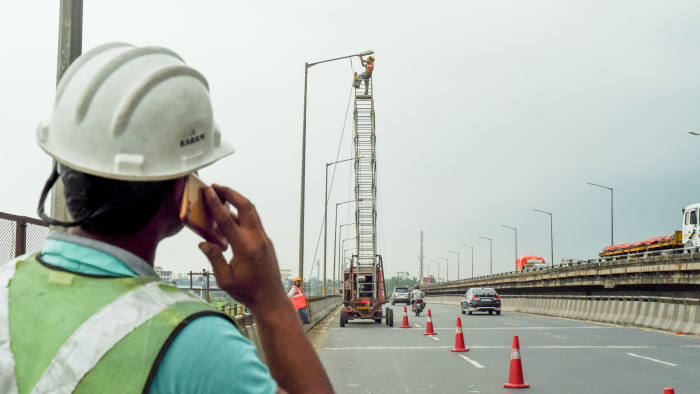 Electrician working for Electric Lamp post , works on upgrading an LED street lamp to it integrating the lights a smart system at the cloudy sky , National Highway 6 on May 22,2018 in West Bengal,India. (Photo by Debajyoti Chakraborty/NurPhoto via Getty Images)