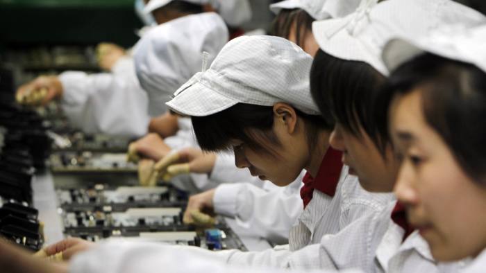 FILE - In this May 26, 2010 file photo, staff members work on the production line at the Foxconn complex in the southern Chinese city of Shenzhen, southern China. A pledge reported Thursday, March 29, 2012 by the manufacturer of Apple's iPhones and iPads to limit work hours at its factories in China could force other global corporations to hike pay for Chinese workers who produce the world's consumer electronics, toys and other goods. Foxconn Technology's promise comes as Beijing is pushing foreign companies to share more of their revenues with Chinese employees. (AP Photo/Kin Cheung, File)