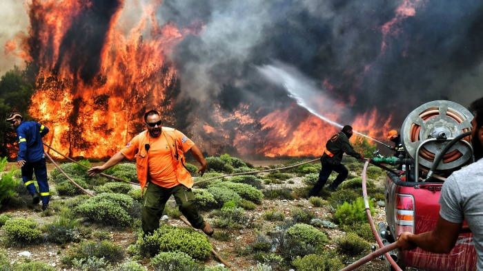 TOPSHOT - CORRECTION - Firefighters and volunteers try to extinguish flames during a wildfire at the village of Kineta, near Athens, on July 24, 2018. Raging wildfires killed 74 people including small children in Greece, devouring homes and forests as terrified residents fled to the sea to escape the flames, authorities said Tuesday. / AFP PHOTO / Valerie GACHE / The erroneous mention[s] appearing in the metadata of this photo by ANGELOS TZORTZINIS has been modified in AFP systems in the following manner: [-VALERIE GACHE--] instead of [--ANGELOS TZORTZINIS -]. Please immediately remove the erroneous mention[s] from all your online services and delete it (them) from your servers. If you have been authorized by AFP to distribute it (them) to third parties, please ensure that the same actions are carried out by them. Failure to promptly comply with these instructions will entail liability on your part for any continued or post notification usage. Therefore we thank you very much for all your attention and prompt action. We are sorry for the inconvenience this notification may cause and remain at your disposal for any further information you may require.VALERIE GACHE/AFP/Getty Images