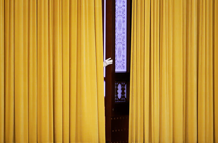 A member of staff appears from behind curtains before the visit of British Prime Minister Theresa May at the Great Hall of the People in Beijing, China January 31, 2018. REUTERS/Jason Lee TPX IMAGES OF THE DAY