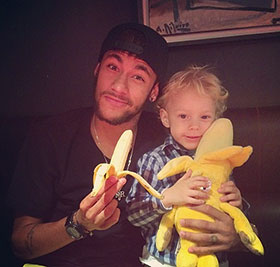 Neymar with his son eating a banana