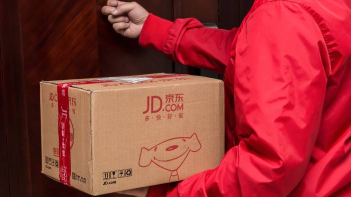 KG8MJE Zhongshan,China-November 3,2017:male courier from JD.com delivering a parcel and knocking the door.Nov 11 is the shopping day in China and many online