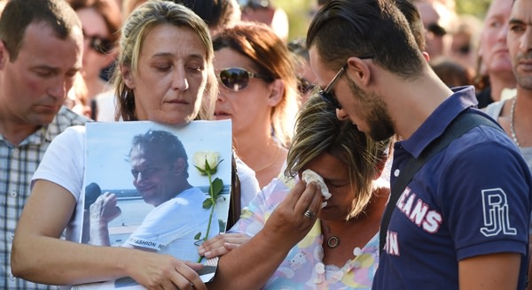 Kevin (R) and Laurence (C), son and wife of Herve Cornara, a man killed and beheaded on June 26, 2015 in a terrorist attack at the Air Products factory in Saint-Quentin-Fallavier, cry during a march in Fontaines-sur-SaÃ´ne near Lyon, on June 30, 2015. Yassin Salhi, 35, confessed to the crime but has maintained it was purely for personal reasons and had nothing to do with his religious beliefs, even though it bore all the hallmarks of a jihadist act. AFP PHOTO / PHILIPPE DESMAZES (Photo credit should read PHILIPPE DESMAZES/AFP/Getty Images)