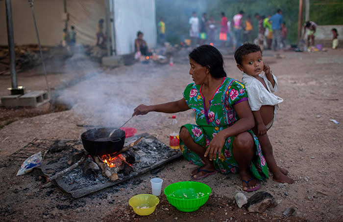 TOPSHOT - Members of the Warao tribe, Venezuela's second-largest indigenous group, prepare food at the Janokoida shelter where they have been taking refuge in the border city of Pacaraima, Roraima State, Brazil, on August 21, 2018. - Desperate Venezuelans fleeing the country's crisis continue to cross the Brazilian border, despite the violent anti-migrant riot that took place last week in the border town of Pacaraima. (Photo by Mauro PIMENTEL / AFP)MAURO PIMENTEL/AFP/Getty Images