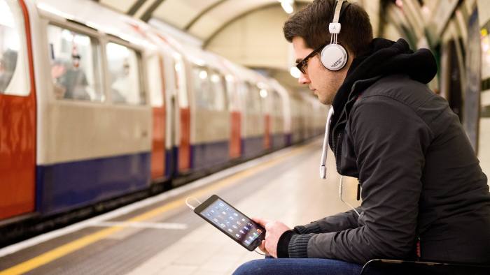 LONDON, UNITED KINGDOM - JANUARY 14: A man using an Apple iPad Mini tablet computer whilst waiting for an underground train on January 14, 2013. (Photo by Will Ireland/Future Publishing via Getty Images)