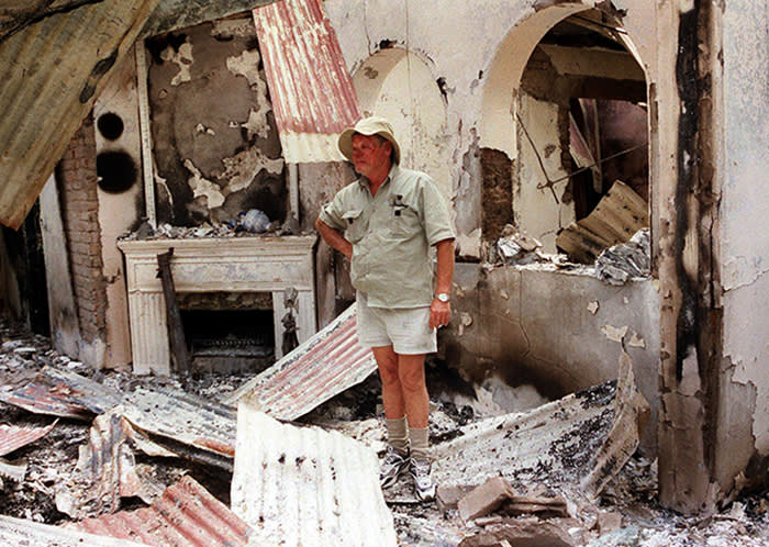 HEADLANDS, ZIMBABWE: Dup Muller, 59, a commercial farmer in Headlands, 110 kilometers, (70 miles) East of Harare, shows his 17th. century clock, 11 August 2002, that was destroyed when his farm house was burnt by suspected war veterans. Scores of white Zwimbabwean farmers have reportedly fled into hiding to avoid arrest as police continued to crack down on them for defying a government order to leave their farms, police said 21 August 2002. AFP PHOTO AARON UFUMELI (Photo credit should read AARON UFUMELI/AFP/Getty Images)