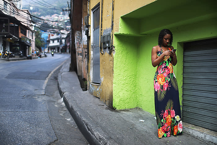 RIO DE JANEIRO, BRAZIL - SEPTEMBER 24: A woman checks her phone in the Rocinha 'favela' community on September 24, 2017 in Rio de Janeiro, Brazil. The Brazilian Army and other armed forces entered the favela September 22 in an ongoing operation following firefights involving drug gangs in the favela, which is one of the largest in Latin America. Rio has suffered an uptick in violence following the Rio 2016 Olympic Games. (Photo by Mario Tama/Getty Images)