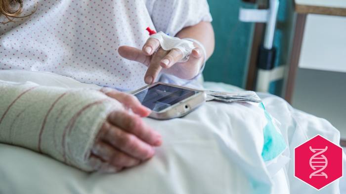 Woman in the hospital, operated hand, using mobile phone, left hand