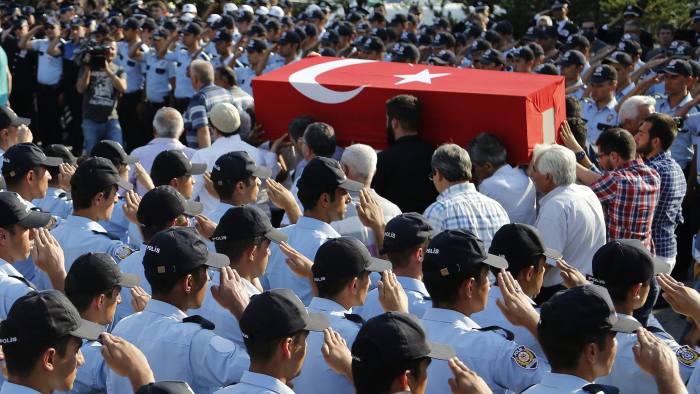 Turkish policemen salute as mourners carry the coffin of a policeman killed on Friday during the failed military coup, at a mass funeral in Ankara, Turkey, Monday, July 18, 2016. Warplanes patrolled Turkey's skies overnight in a sign that authorities feared that the threat against President Recep Tayyip Erdogan's government was not yet over, despite official assurances that life has returned to normal after a failed coup. (AP Photo/Hussein Malla)