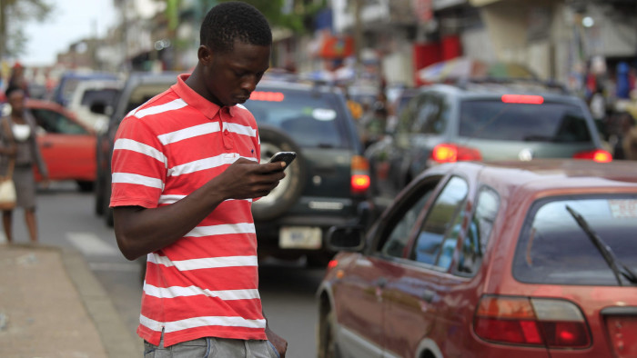 epa05267151 A photograph made available 19 April 2016 shows a man using a cellphone in Monrovia, Liberia 18 April 2016. The mobile industry in West Africa has grown from a state controlled space to becoming a massive market fueling economic growth and technological innovation. Mobile network operators have stiff competion between each other for the millions of African consumers looking to connect in an easy and affordable way. The cellphone industry has in many instances circumvented the problematic fixed line infrastructure of existing telecommunications networks. Proponents to this growth in mobile technology include a World Bank investment of $50 million USD in infrastructure development and capacity building as well as a fiber optic submarine West African Cable System (WACS) aimed at dramatically increase broadband capacity for the region. EPA/AHMED JALLANZO