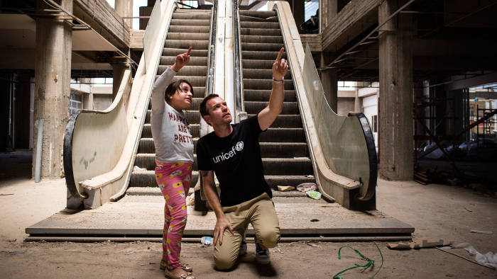 Mirna, aged 11, shows Ewan McGregor the abandoned, half-finished shopping mall, where she lives with her family in Erbil, Iraq