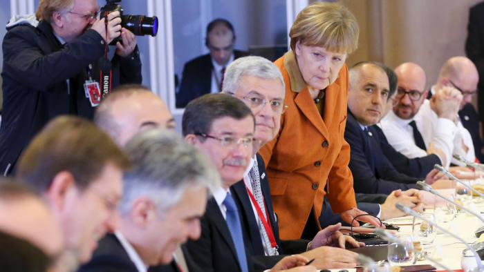 Turkish Prime Minister Ahmet Davutoglu (4th L), German Chancellor Angela Merkel (4th R) and other European leaders attend the lunch of a European Union leaders' summit with Turkey on the migrant crisis at the European Council in Brussels, on March 7, 2016. EU leaders held a summit with Turkey's prime minister on March 7 in order to back closing the Balkans migrant route and urge Ankara to accept deportations of large numbers of economic migrants from overstretched Greece. The European Union is hardening its stance in a bid to defuse the worst refugee crisis since World War II by increasingly putting the onus on Turkey and EU member Greece in return for aid. / AFP / POOL / OLIVIER HOSLETOLIVIER HOSLET/AFP/Getty Images