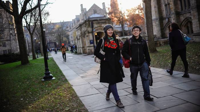 In this Nov. 20, 2014 photo, Yale University sophomore Yupei Guo, left, walks with friend Joseph Lachman on the school's campus in New Haven, Conn. With more undergraduates coming from overseas than ever, some Ivy League universities are reaching out in new ways to attract international students of more varied backgrounds -- and particularly from China, which sends more students to the U.S. than any other country. (AP Photo/Jessica Hill)