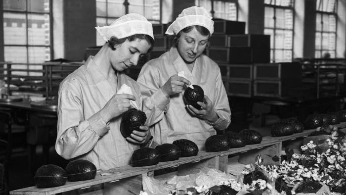 Two women at the Cadbury's chocolate factory in Bournville, in the West Midlands join together chocolate Easter egg halves
