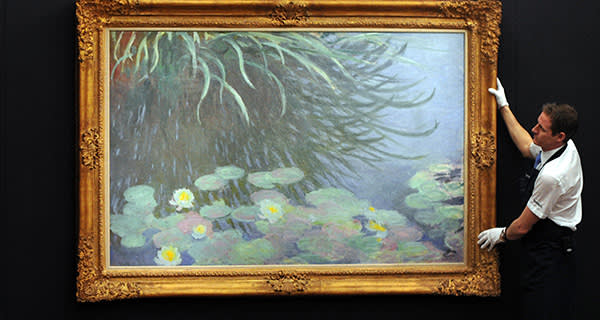 A member of staff poses with a painting entitled 'Nympheas avec reflets de hautes herbes' by French artist Claude Monet at Sotheby's auction house in central London on January 31, 2013. Due to form part of the Impressionist and Modern Art Evening Sale on February 5, it is expected to fetch between 12-18 million GBP (15-22 million EUR - 19-29 million USD). AFP PHOTO / CARL COURT (Photo credit should read CARL COURT/AFP/Getty Images)