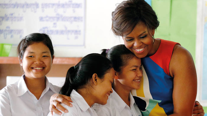US first lady Michelle Obama, center, hugs students at a local high school that she visited with Bun Rany, the first lady of Cambodia, second right, Saturday, March 21, 2015, on the outskirts of Siem Reap, Cambodia. Mrs. Obama is in Cambodia to promote the education initiative "Let Girls Learn," which was launched to lift barriers that block more than 62 million girls around the world from attending school. (AP Photo/Wong Maye-E)