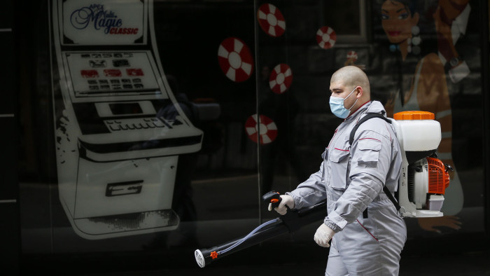 BELGRADE, SERBIA - APRIL 01: A man wearing protective gear spray disinfectant on April 01, 2020 in Belgrade, Serbia. Serbian President Aleksandar Vucic had declared the state of emergency to stop the spread of the coronavirus. Many public spaces are shut and soldiers are guarding hospitals. (Photo by Srdjan Stevanovic /Getty Images)
