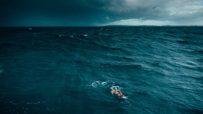 Renowned endurance swimmer and United Nation’s Environment Programme (UNEP)’s Patron of the Oceans, Lewis Pugh swims ahead of a rain squall in Lyme Bay, United Kingdom during The Long Swim campaign on 28 July 2018.