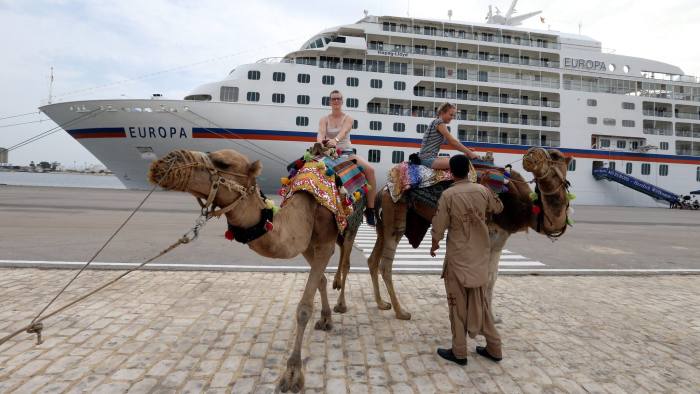 epa05573119 German Tourist ride camels after the cruise ship 'EUROPA' of the Hapag-Lloyd Cruises docked at La Goulette port of Tunis, Tunisia, 06 October 2016. German cruise ship docked for the first time since March 2015 terror attack that targeted Bardo National Museum in Tunis and left 21 tourists dead. EPA/MOHAMED MESSARA