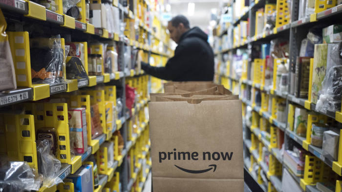 FILE - In this Dec. 20, 2017, file photo, a clerk reaches to a shelf to pick an item for a customer order at the Amazon Prime warehouse in New York. Amazon's Prime Day starts July 16, 2018, and will be six hours longer than last year's and will launch new products. Amazon hopes to keep Prime attractive for current and would-be subscribers after raising the annual membership fee by 20 percent to $119 and to $12.99 for the month-to-month option.. (AP Photo/Mark Lennihan, File)