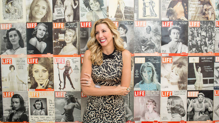 Spanx founder Sara Blakely poses for a portrait in her office against a wall of LIFE magazine covers