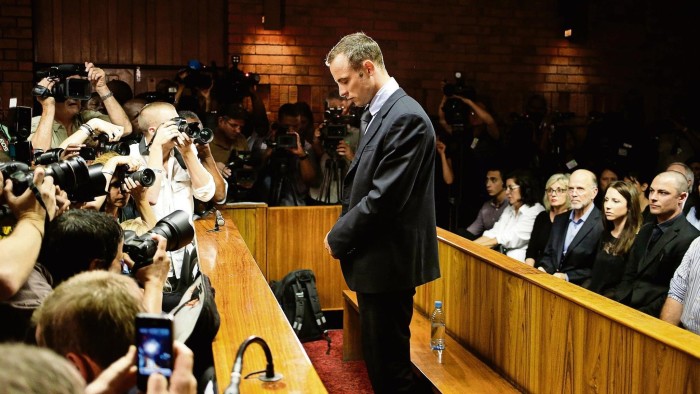 Oscar Pistorius stands at the dock before the start of proceedings at a Pretoria magistrates court February 22, 2013. &quot;Blade Runner&quot; Pistorius, a double amputee who became one of the biggest names in world athletics, was applying for bail after being charged in court with shooting dead his girlfriend, 30-year-old model Reeva Steenkamp, in his Pretoria house. REUTERS/Mike Hutchings (SOUTH AFRICA - Tags: CRIME LAW SPORT ATHLETICS TPX IMAGES OF THE DAY) - RTR3E3ZO