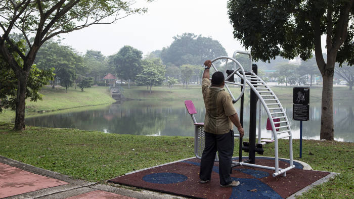 A man exercises at a park along Putrajaya Lake in Putrajaya, Malaysia, on Thursday, Oct. 1, 2015. Malaysia may miss a goal to balance its budget by 2020 as a plunge in commodity prices forces the government to cut its projections, according to Prime Minister Najib Razak. Photographer: Charles Pertwee/Bloomberg