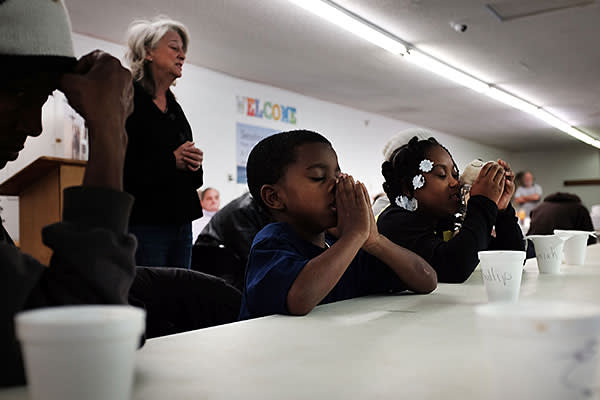 A family prays before a meal at the Seashore Mission which offers services to the homeless and those in need on January 3, 2016 in Biloxi, Mississippi