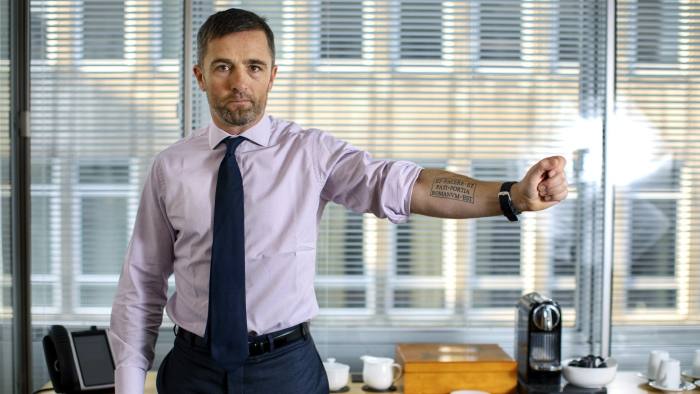 Hugo Varney with tattoo at his London office