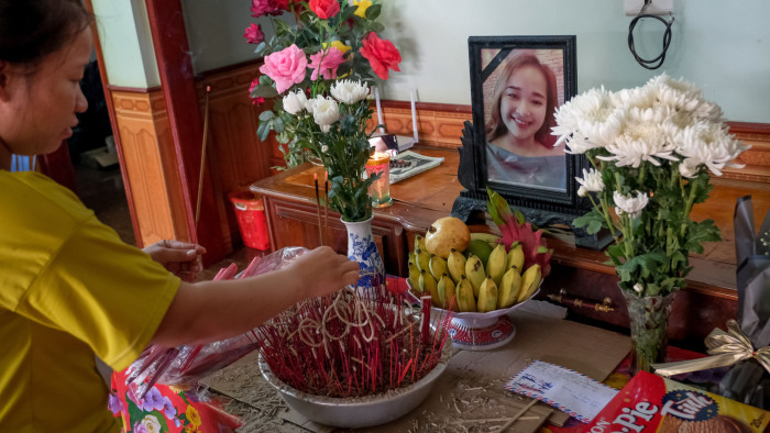 NGHE AN, VIETNAM - OCTOBER 28: Bui Thi Phuong, 25, lights incense at a makeshift shrine with the photo of her younger sister Bui Thi Nhung, believed to be one of the 39 victims found dead in a refrigerated truck in Britain, at their house on October 28, 2019 in Nghe An province, Vietnam. A lorry was discovered early Wednesday morning in Waterglade Industrial Park on Eastern Avenue in the town of Grays. Authorities said they believed the lorry originated in Bulgaria and entered the country at Holyhead on October 19. The suspected driver was arrested in connection with the investigation. (Photo by Linh Pham/Getty Images)