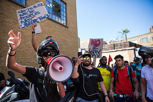 Workers protest pay cuts outside the UberEats office in London, August 26