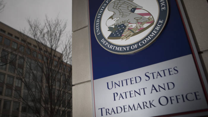 The U.S. Patent and Trademark Office (USPTO) seal is displayed outside the headquarters in Alexandria, Virginia, U.S., on Friday, April 4, 2014. The Senate Judiciary Committee tomorrow plans to mark up a measure that would curb the activities of so-called patent trolls after pulling back the bill last week in the face of opposition from such companies as 3M Co., AstraZeneca Plc, Monsanto Co. and Procter & Gamble Co. Photographer: Andrew Harrer/Bloomberg