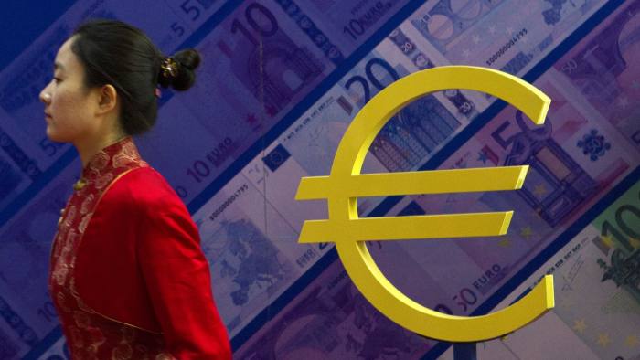 A hostess walks past the euro sign at an exhibition about currencies in Beijing, China, Wednesday, Feb. 15, 2012. China's Central Bank Governor Zhou Xiaochuan said Beijing has confidence in the euro and will keep buying the debt of European governments. (AP Photo/Alexander F. Yuan)