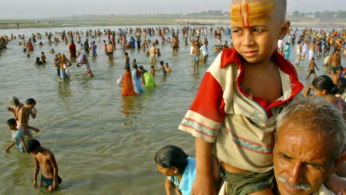 Ram Pal Yadav carries his son Sooraj on his shoulder, as others take holy dips at the Sangam, the confluence of the Rivers Ganges, Yamuna the mythical Saraswati, in Allahabad, India, Friday, June 17, 2005. Hindus across the country are celebrating Ganga Dussehra, devoted to the worship of the River Ganges. (AP Photo/Rajesh Kumar Singh)