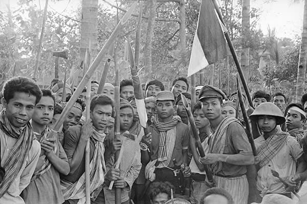 Indonesian nationalists in 1965 carrying bamboo weapons and hatchets in Java