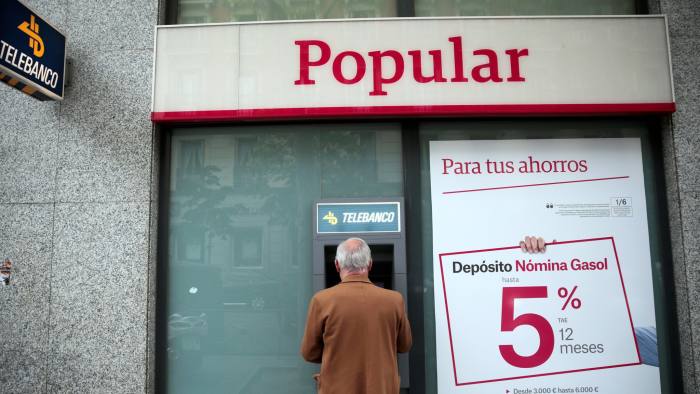 A man uses a cash dispenser at a Banco Popular branch in Madrid, Spain, April 29, 2016. REUTERS/Andrea Comas - RTX2C5VC