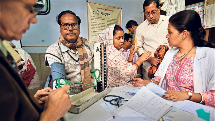 A doctor and nurse at the Ramakrishna Mission take blood pressure of the poor, ill with diabetes