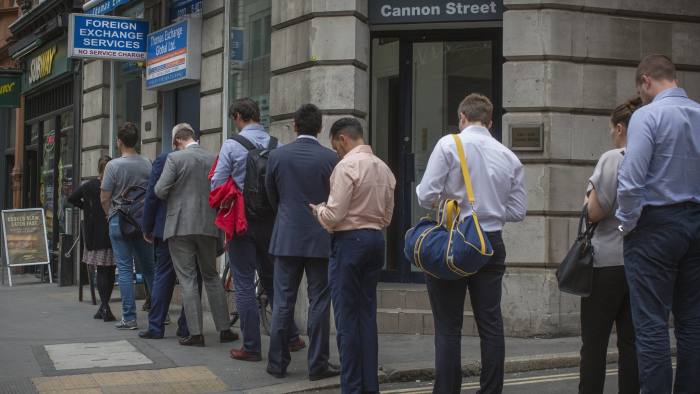 People queue to exchange money on Cannon Street, London ahead of the EU referendum vote tomorrow.