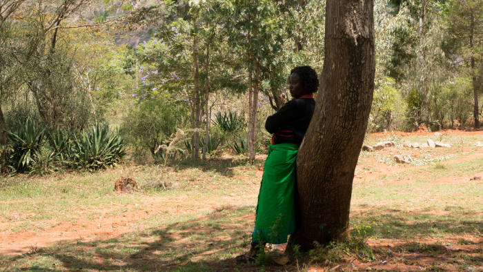 Wayu Kisilu stands off to the side as the women’s group discusses the possibility to giving her a new loan during a meeting in Kyangala, Kenya, November 15, 2018.