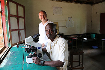 Piot with Sukato Mandzomba in the latter’s makeshift laboratory in Yambuku