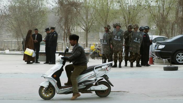 Police officers check the identity cards of a people as security forces keep watch in a street in Kashgar, Xinjiang Uighur Autonomous Region, China, March 24, 2017. REUTERS/Thomas Peter - RC1A412EF700