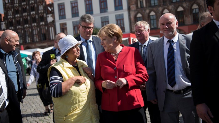 German Chancellor Angela Merkel (C) and Christian Democratic Union (CDU) party's candidate Egbert Liskow (R) in the forthcoming regional electon in Mecklenburg-Vorpommern visit a market in Greifswald, Germany August 30, 2016. REUTERS/Stefanie Loos - RTX2NLKD